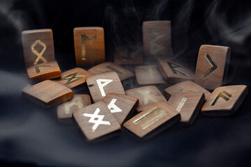 smoke covers the runes that lie on a dark background	
