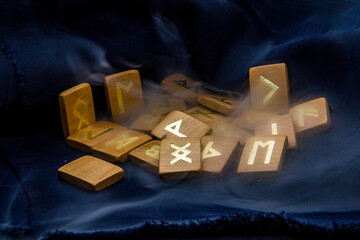 Smoke around wooden runes on black background	
