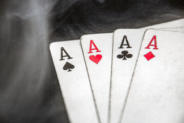 Smoke descends to the four aces of playing cards	

