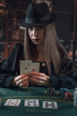 Beautiful woman playing poker in casino and hold two aces as a winning combination