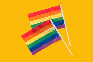 LGBT rainbow flag flat lay on yellow color background. gay marriage, human rights, june parade, lgbtq proud history month concept, coming out day. top view, place for text or logo