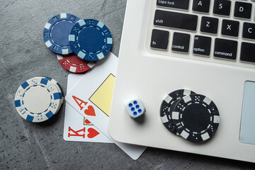 Online game concept poker playing cards and chips with laptop