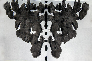 Black ink on white paper creates a figure in a psychological Rorschach test close-up	

