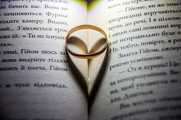 Wedding Ring stands between the pages of a book	
