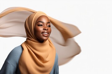 Portrait of beautiful black skin woman wearing hijab over white png background. Waving head scarf, femininity, concept of goods for muslim islamic women. Copy space for text and design.