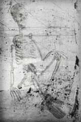 empreinte d'un squelette homme en position assise, incrusté dans un vieux mur