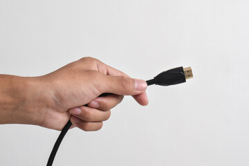 Hand holding HDMI cable connector on white background
