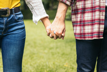 Interracial couple taking a walk hand in hand in the park