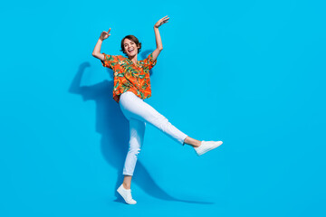 Full size photo of pretty overjoyed girl good mood enjoy dancing empty space ad isolated on blue color background