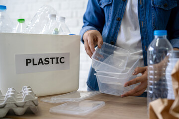 Waste disposal and recycling. Woman separates plastic waste for recycling.