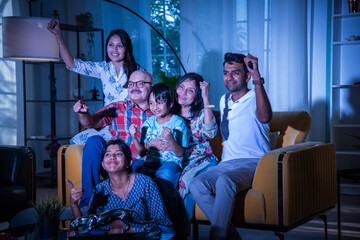 Indian big family watching television at home on sofa