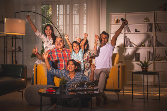 Indian big family watching television at home on sofa