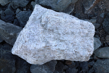 Large pegmatite spodumene ore rock amongst waste (barren in lithium). Commercial Lithium (Li)...
