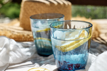 Summer refreshing lemonade drink or non alcoholic cocktail with lemon slices in blue drinking...
