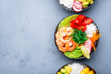 Poke bowl for balanced nutrition. Set with  tuna, salmon, shrimp avocado, mango, radish, white rice and other ingredients. Gray table background, top view