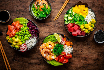 Balanced diet poke bowls with tuna, salmon, shrimp, vegetables, legumes, avocado and rice, wood...