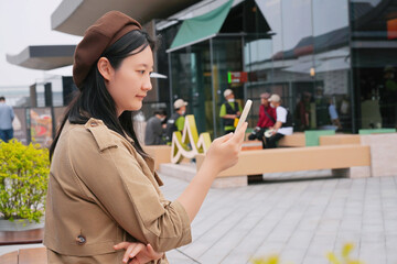 Young Woman Checking Phone in Busy Urban Area