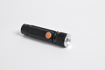 Modern metal LED flashlight in black color isolated on white background. Portable flashlight, LED...