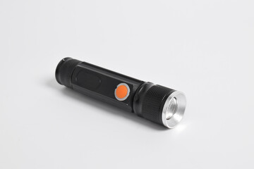 Modern metal LED flashlight in black color isolated on white background. Portable flashlight, LED camping flashlight