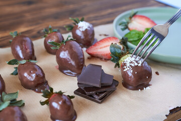 Chocolate dipped strawberries on a wooden table. Selective focus.
