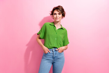 Photo of positive adorable young woman dressed green shirt hands arms pockets isolated pink color background