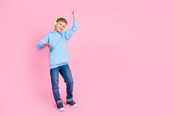 Full body photo of small cheerful boy enjoy favorite song headphones dance empty space isolated on...