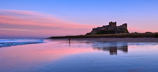 Sunset on Bamburgh Castle, on the northeast coast of England, by the village of Bamburgh in...