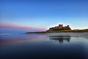 Sunset on Bamburgh Castle, on the northeast coast of England, by the village of Bamburgh in...