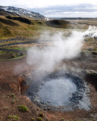 Reykjadalur Valley in autumn snow and hot springs, boiling mud pits, Iceland