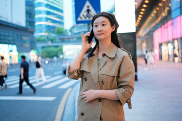 Young Woman on Phone Stroll in Bustling City Evening