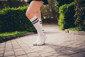 Cropped photo of girl legs wear school short skirt white knee high socks shoes walking college outside urban city park