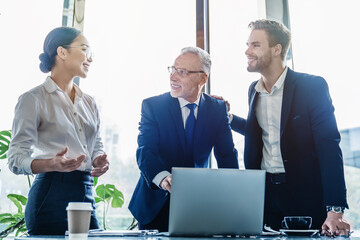 Young asian businesswoman putting forward her suggestions to colleagues in modern office. Group of...