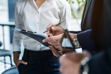 Close up shot of business colleagues discussing over report document at work. Startup business team analyzes documents with graphs and charts in a modern office.