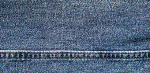 texture of blue jeans denim fabric with seam background	