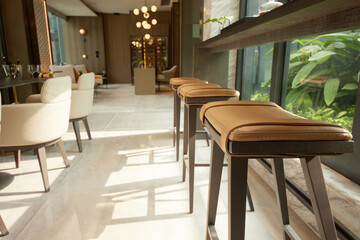 Modern bar stools and elegant interior illuminated by natural light