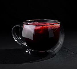 Elegant glass of red tea on dark background