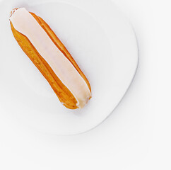 Fresh eclair on white plate isolated on white background
