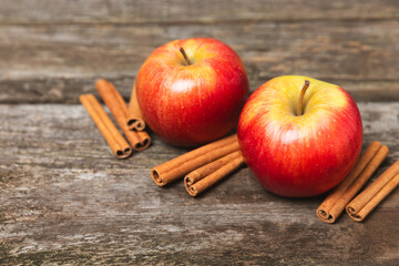 Apples with cinnamon on a textured wooden background. Fragrant red spiced apples with cinnamon...