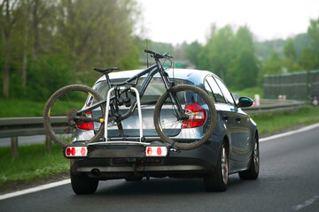 car with bicycles on the roof on a mountain road. Sports bikes mounted on the roof rack of the truck