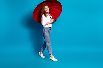 Photo portrait of nice young lady hold umbrella walking wear trendy white garment isolated on blue...