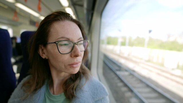 In the cozy atmosphere of public transport, a portrait of a middle-aged woman in fashionable glasses appears, expressing her personality and style.
