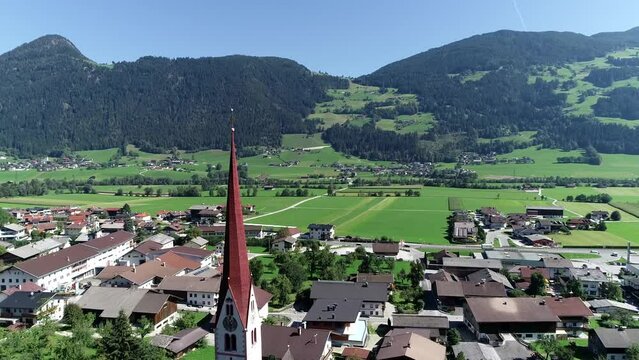Aerial view moving towards Pfarrkirche located in Schlitters a small town in Zillertal valley in Austria near the strongly glaciated section of the Alps also most visited by tourists in the area 4k
