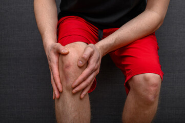 Mężczyzna biegacz trzyma się za kolano, ból kolan