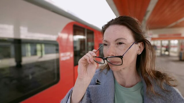 A charismatic middle-aged woman with glasses naturally fits into the atmosphere of public transport, creating an image of confidence and style.