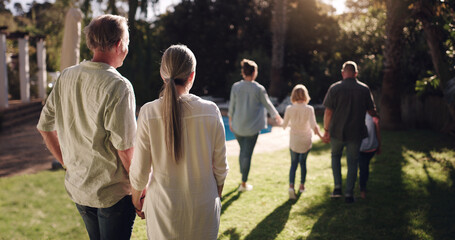 Big family, love and walking together in garden for sunset, bonding and peace in nature. Grandmother, grandfather and kids in park or backyard for happiness, view and satisfied with life or journey