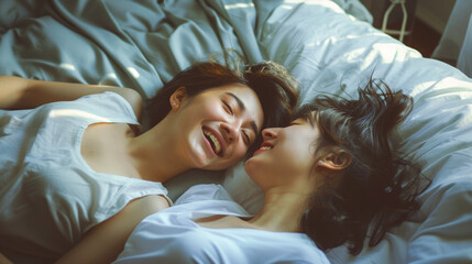 LGBT concept, Asian gay lover, just married homosexual couple lying on bed together in bedroom. Playing and smile laughing with happiness and kissing on forehead. Happy gay and lesbian lifestyle. Stoc
