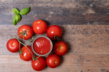 fresh and canned tomatoes with basil on wooden table, top view, space for text,