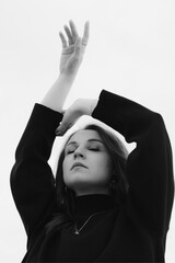 Beautiful girl on the background of the city. The embodiment of inner peace and tranquility. Black and white photo