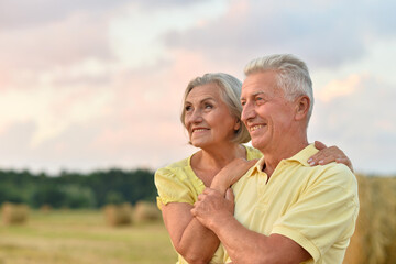 Beautiful elderly couple in a field against the sky
