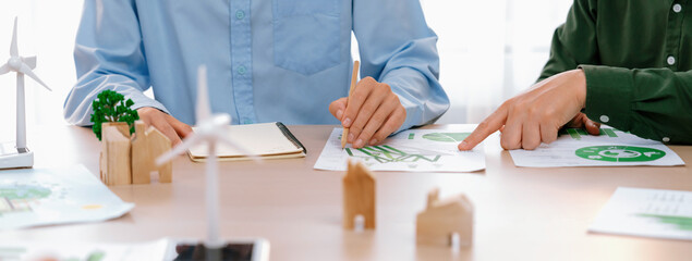 Business people invest in green business plan at meeting room on table with house model and wind...